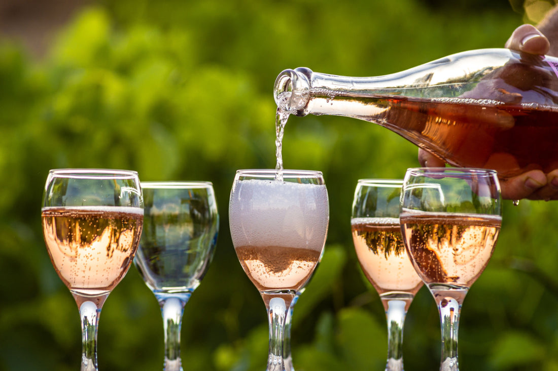four glasses of sparkling wine being filled